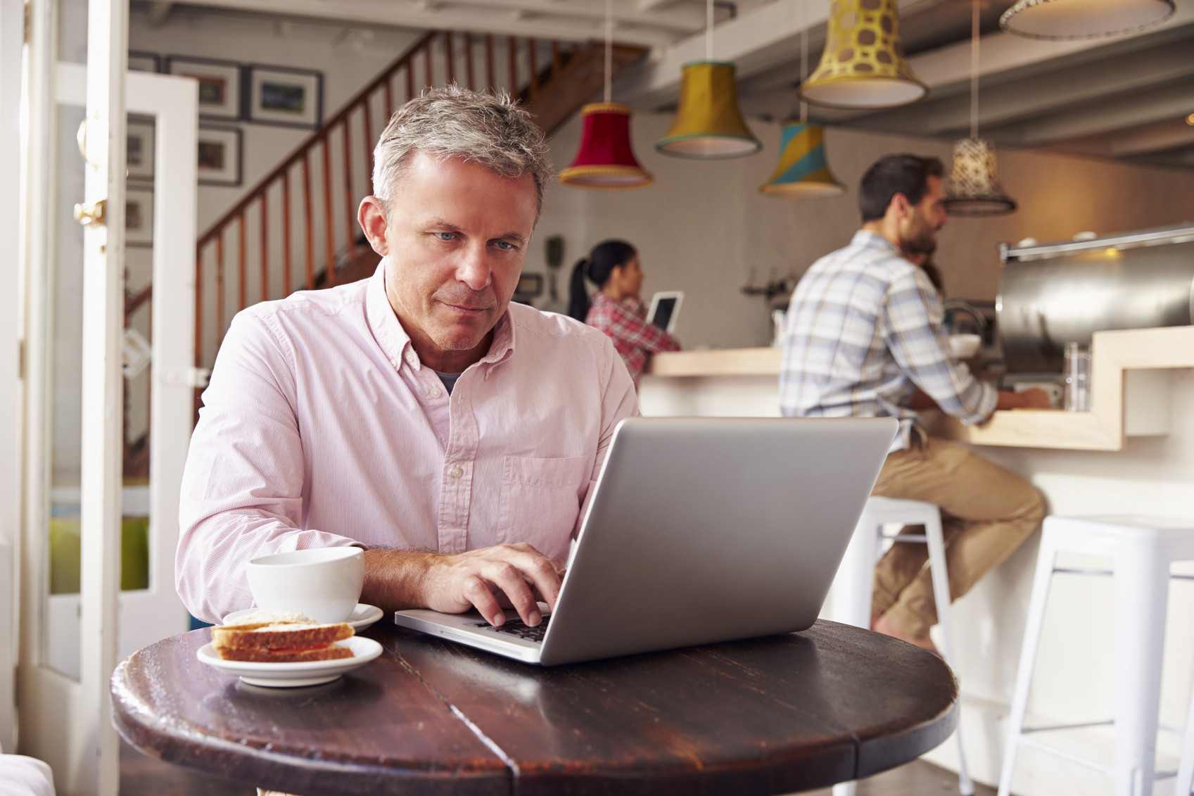 middle aged man in a coffee shop working at the supplemental real estate exam prep on his laptop